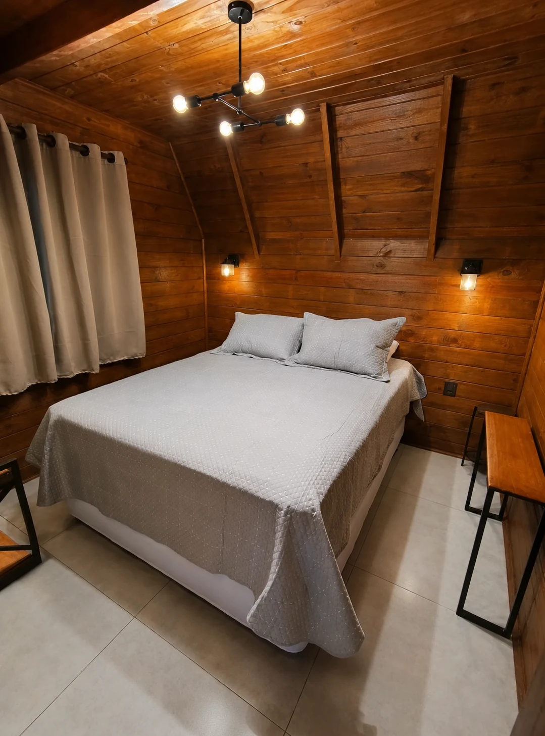 Quarto auxiliar com cama queen e acabamento em madeira