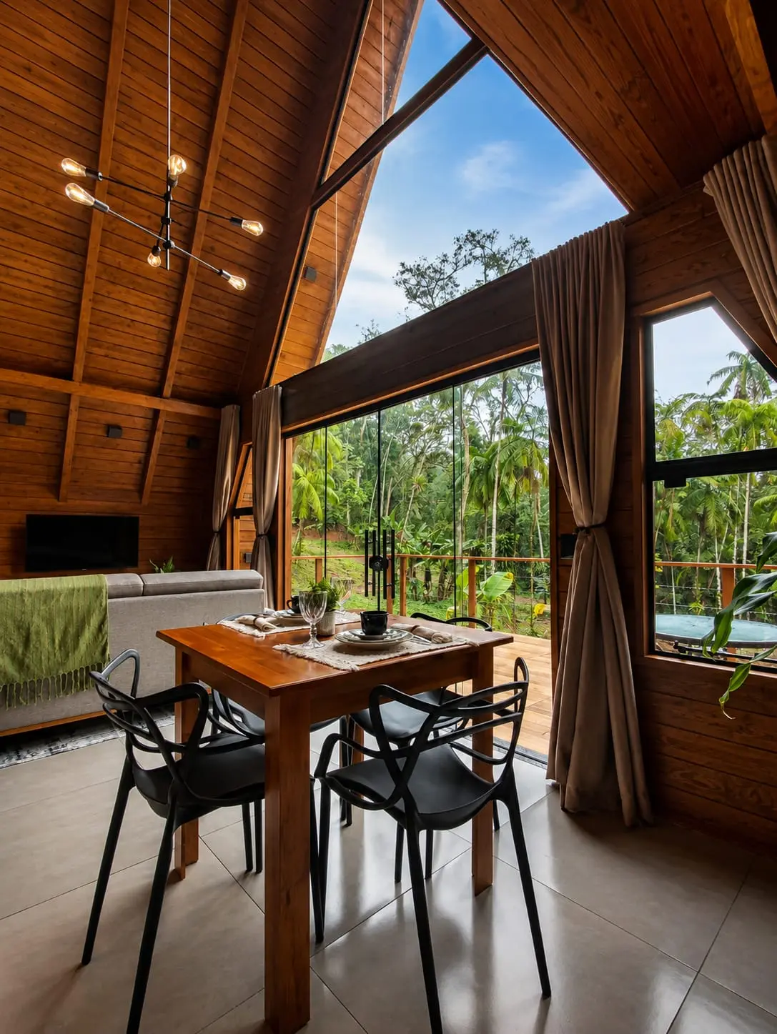Ambiente integrado em madeira com sala de jantar e vista para a mata